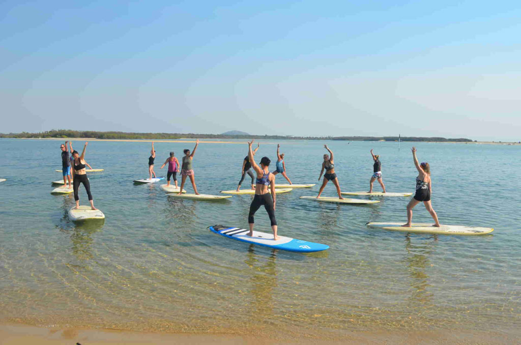 Stand up paddleboard yoga class on calm water with Yoga with Ashleigh
