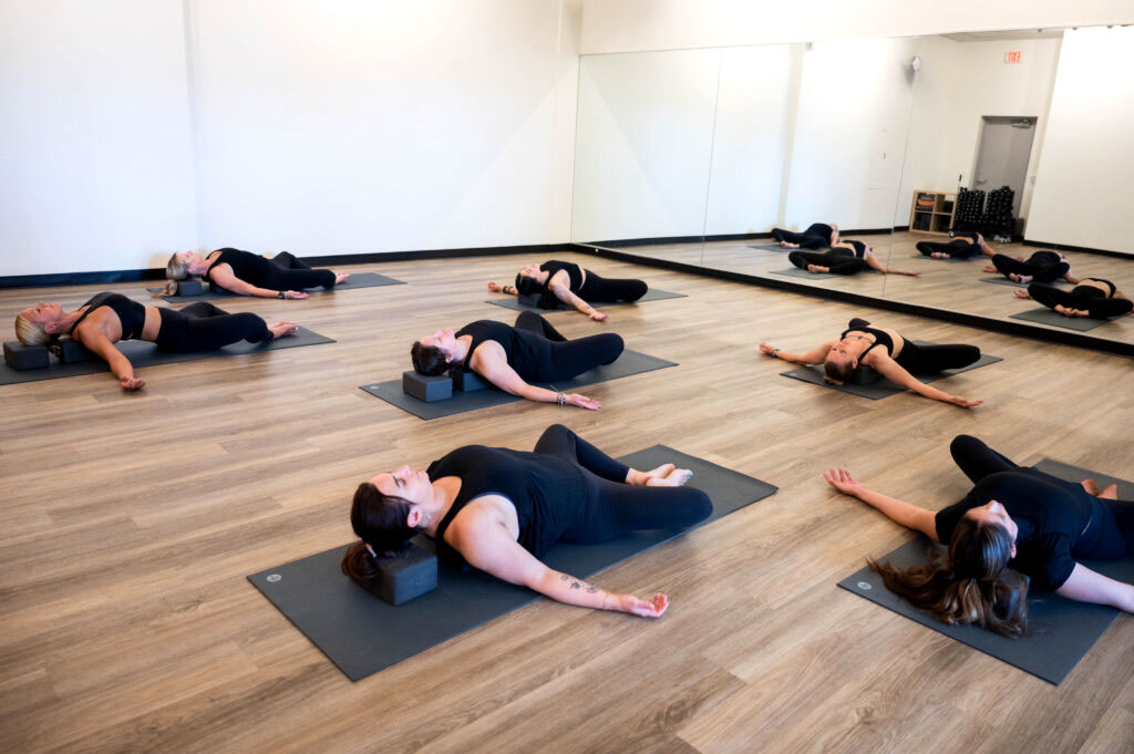 Yin yoga class with participants in a restorative floor pose using blocks at Yoga with Ashleigh